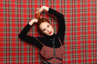 Kızıl saçlı kız kendini kuyruğundan çeker.