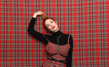 Kızıl saçlı kız kendini kuyruğundan çeker.