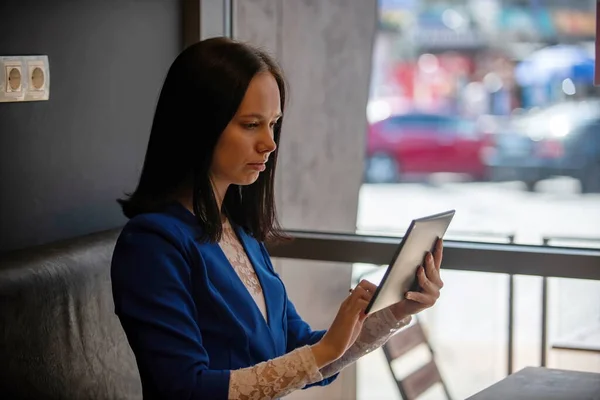 Ein Mädchen in blauer Jacke mit einem Grafik-Tablet. — Stockfoto