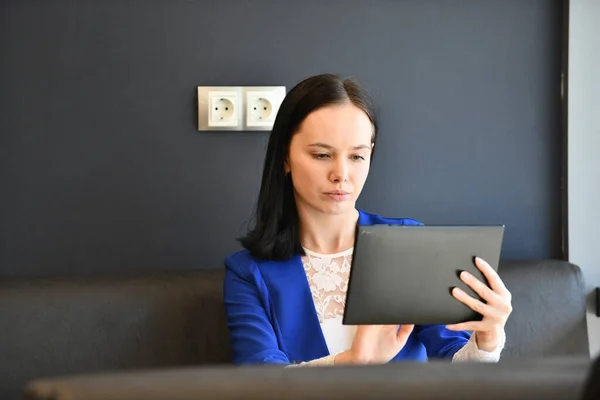 Seorang gadis dalam jaket biru menggunakan tablet grafis . — Stok Foto