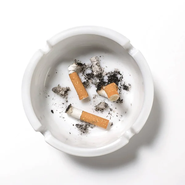 Cigarros em cinzeiro sobre fundo branco — Fotografia de Stock