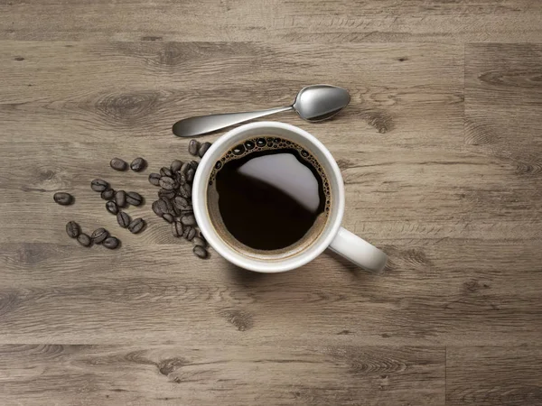 Kaffeebecher mit Löffel und Kaffeebohnen auf Holztisch — Stockfoto