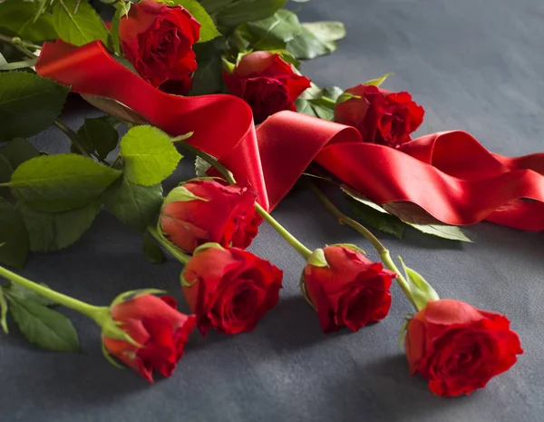 Серый камень с кучей красных роз — стоковое фото