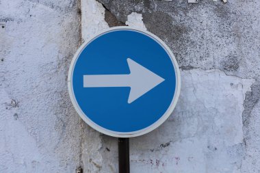 One way sign pointing scratched wall