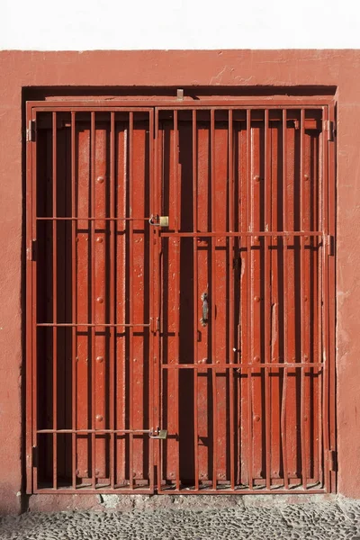 Antique slide steel door locked. Old style of close red steel door. Folding steel door texture pattern and background