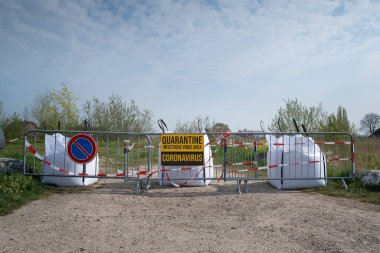Koronavirüs karantinası kavramı. Coronavirus, bulaşıcı bir yerin girişindeki kontrol bariyerindeki dur işaretinde yazıyor. Yol kapatıldı, kontrol