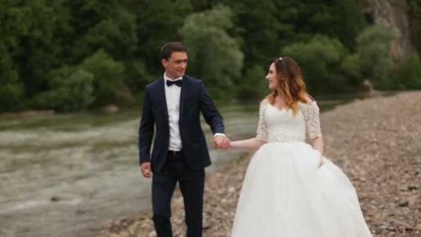 Gelin ve damat nehir kenarında elele — Stok video