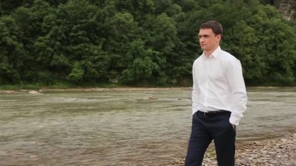 Стильний наречений, що йде біля річки — стокове відео