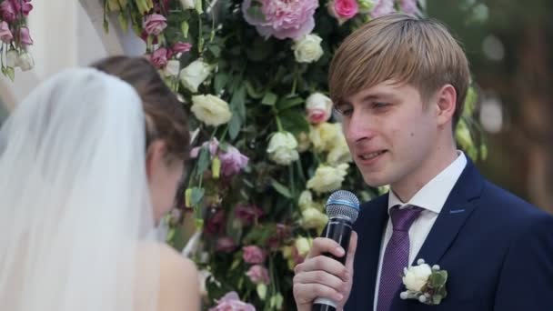 Frischvermähltes Paar steht vor Hochzeitsbogen — Stockvideo