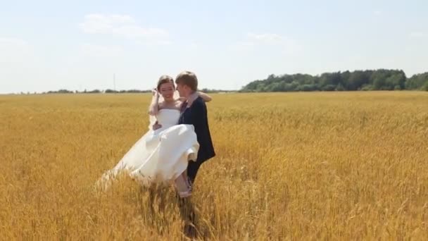 Bruid en bruidegom hebben een leuke op het tarweveld — Stockvideo