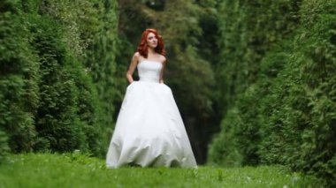 İnanılmaz Kızıl saçlı gelin yeşil ağaçlar yürür
