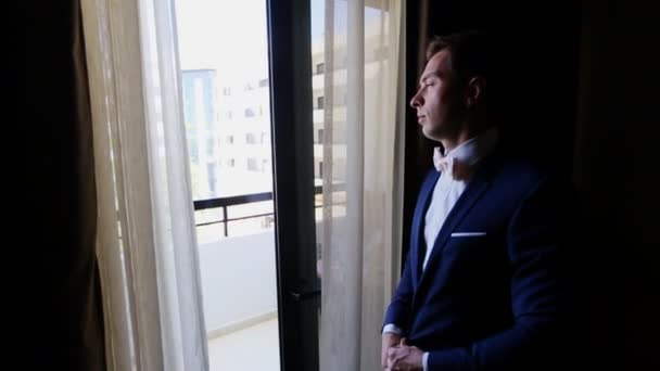 Hombre endereza su corbata en la ventana — Vídeos de Stock