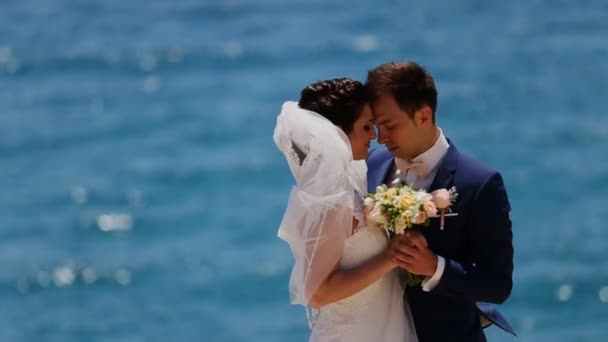 Женатые обнимаются на фоне моря — стоковое видео