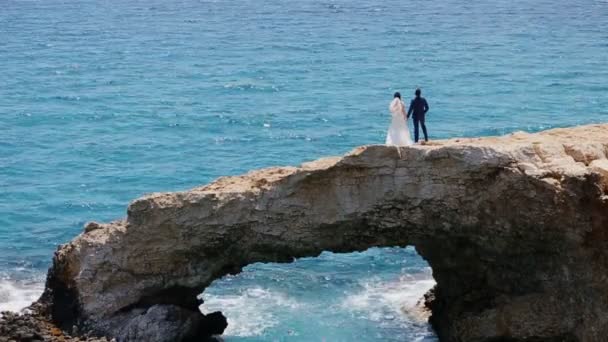 Braut auf einer Steinbrücke im Meer — Stockvideo