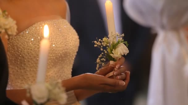 Young couple in the church holds wedding candles — Stock Video