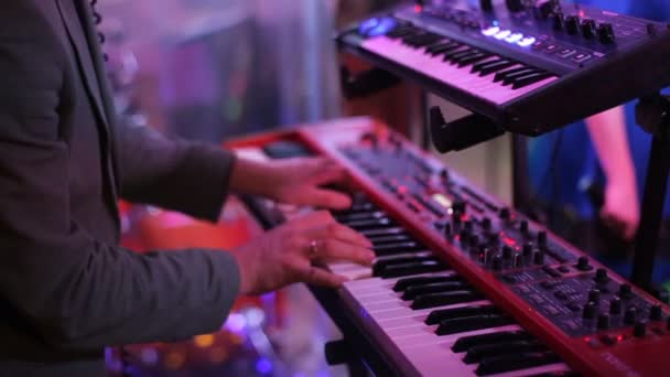 Primer plano: Hombre músico tocando el piano eléctrico en el escenario en un concierto . — Vídeos de Stock