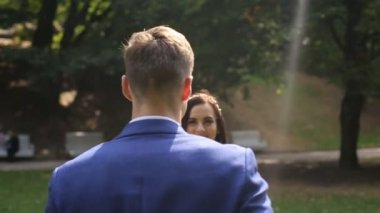 Gelin ve damat birbirine güneşli parkta sarılmak