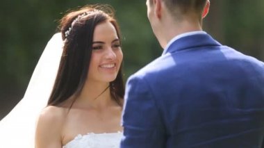 Gelin ve damat birbirine güneşli parkta sarılmak
