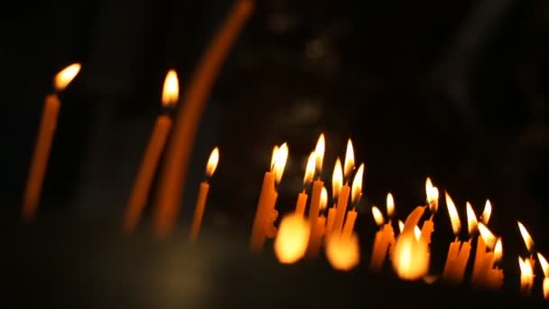 A queimar velas. Um monte de velas estão queimando em um castiçal . — Vídeo de Stock