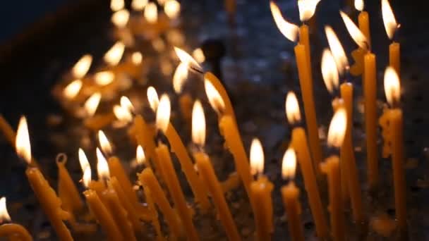 Quemando velas. Muchas velas arden en un candelero. . — Vídeo de stock