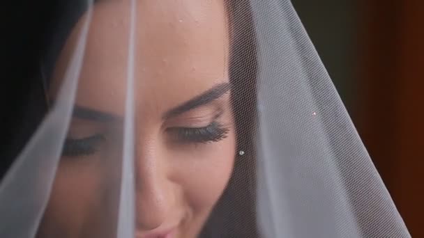 Το πρόσωπό της όμορφο νεαρό νύφης κάτω από το πέπλο λευκό γάμο — Αρχείο Βίντεο