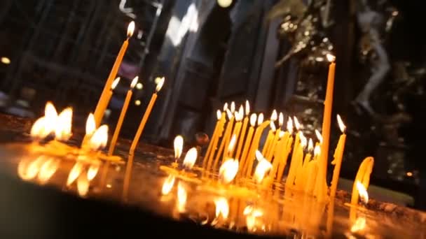 Las velas de la Iglesia se encienden en la Iglesia - la petición de oración ante el Señor y un símbolo de las oraciones de un creyente. La llama de la vela en la Iglesia es la imagen de la Luz eterna . — Vídeos de Stock