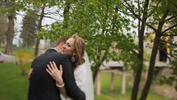 Jonge bruid en bruidegom n een zonnige park — Stockvideo