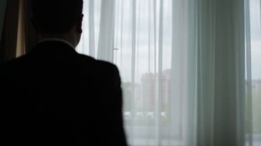 Ceketini arka planda büyük bir şehrin üzerine koyarak bir adam silüeti