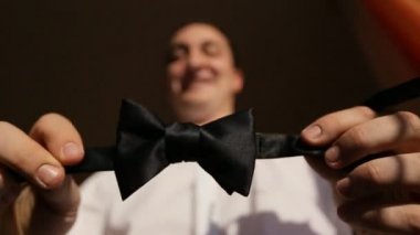 Damat kravatını kamerada gösteriyor.