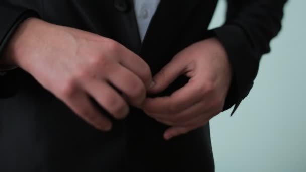 Buttoning a jacket. Stylish man in a suit fastening buttons on his jacket preparing to go out. Close up — Stock Video