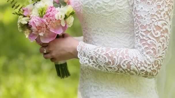 Невеста держит свадебный букет в медленном движении — стоковое видео