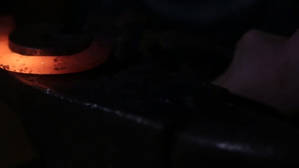 Blacksmith Forges Horseshoe. A blacksmith pounding a hammer on red-hot horseshoe on the anvil. The blacksmith holds a horseshoe steel tongs — Stock Video