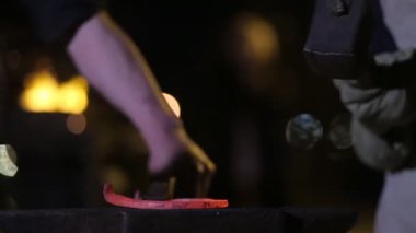 Demirci Forges at nalı. Bir çekiç örs üzerinde kırmızı-sıcak nal vurma bir demirci. Demirci nal çelik maşa tutar