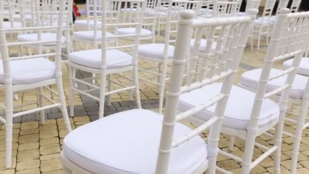 Dolly av rader med stolar på ett bröllop från mittgången och från baksidan — Stockvideo