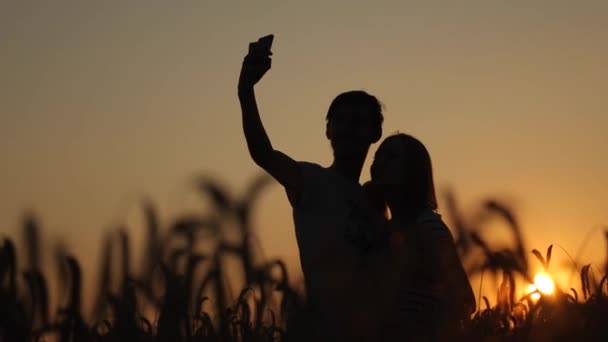 Selfie schieten een meisje met een vent op zonsondergang slow motion video — Stockvideo
