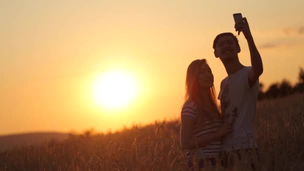 Selfie atirar uma menina com um cara no pôr do sol vídeo em câmera lenta — Vídeo de Stock