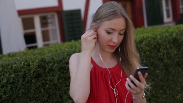Девушка слушает музыку на телефоне через приложение — стоковое видео