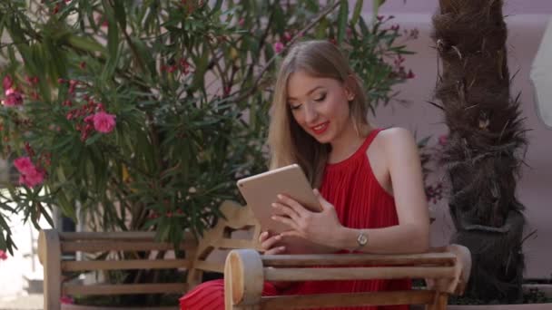 Gyönyörű fiatal nő, egy tabletta Pc. A lány használja a táblaszámítógép könyv — Stock videók