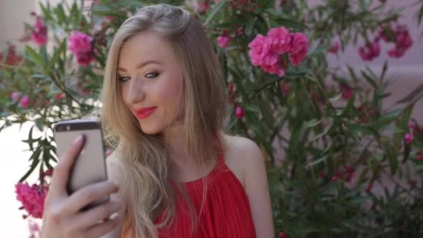 Досить дівчинки підлітка використовує її телефон за межами, вона пози для на Selfie — стокове відео