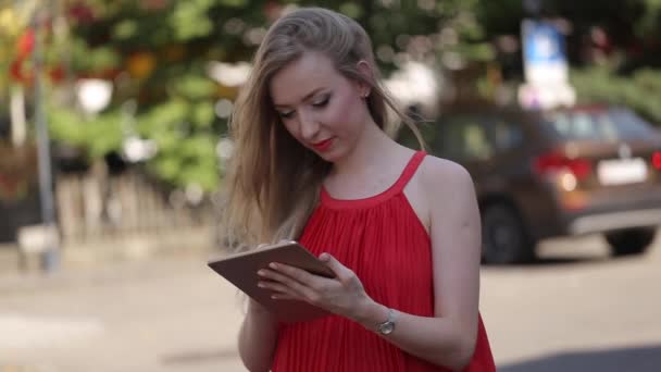 Hermosa mujer joven con una tableta PC. La chica usa una tableta como libro — Vídeos de Stock