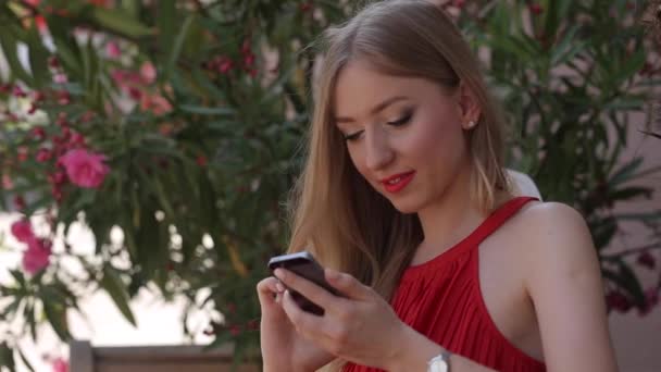 Жінка в літньому одязі друкує на вашому телефоні — стокове відео