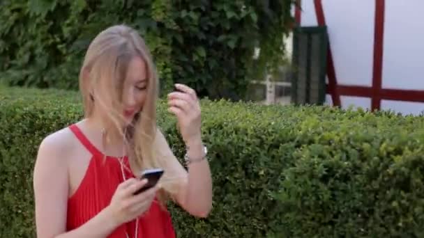 Ragazza che ascolta musica sul telefono attraverso l'app — Video Stock