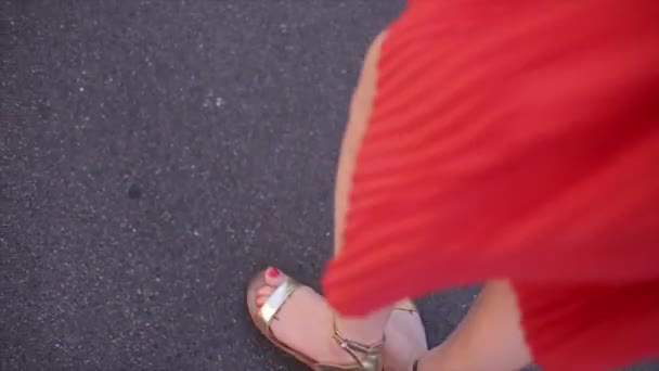 Молодая красивая девушка в красном платье идет весело — стоковое видео