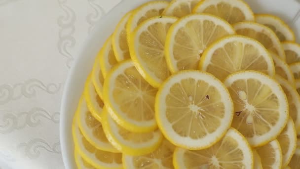 Juicy lemon with slices on plate rotating, top shot — Stock Video