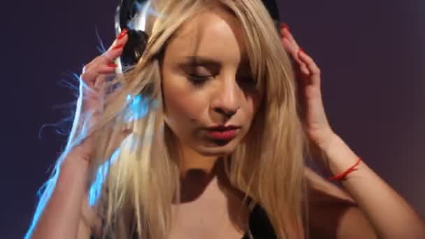Ung kvinna lyssnar musik genom hörlurar slowmotion — Stockvideo