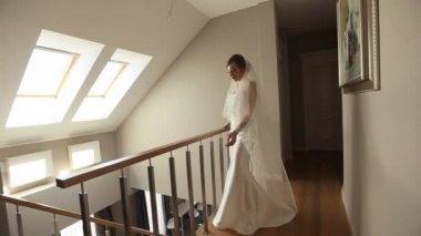 Gelin evinde merdivenlerin yanında duruyor