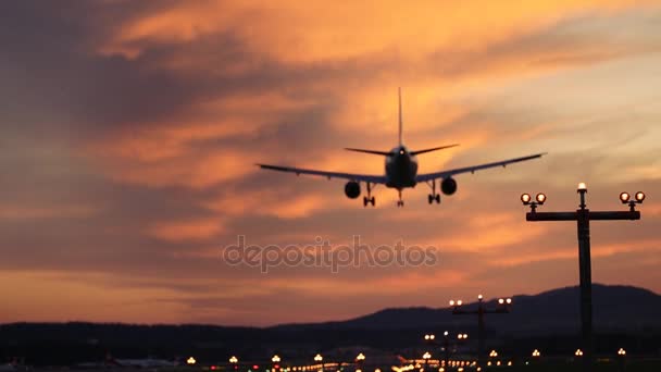 Atterrissage de l'avion à l'aéroport au coucher du soleil 