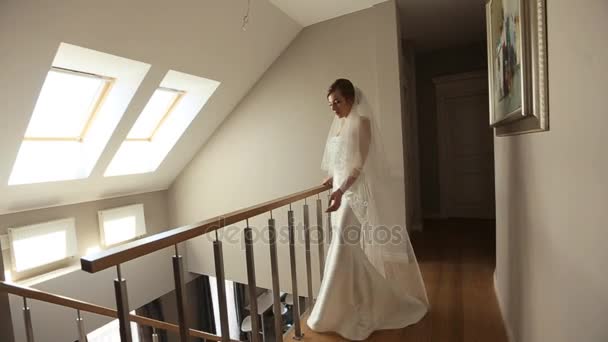 La mariée est debout près des escaliers de la maison — Video