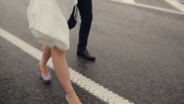 Ноги жениха и невесты закрываются под дождем — стоковое видео