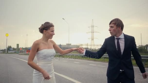 Mariée et marié courant à la pluie et sentant — Video